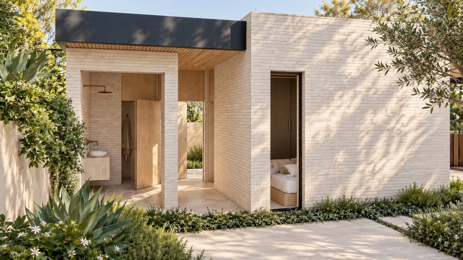 Brick pavilion with an open outdoor shower and a bedroom window among agave and star jasmine